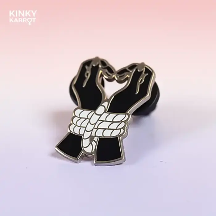 bound hands enamel pin with two black-gloved hands tied in white rope
