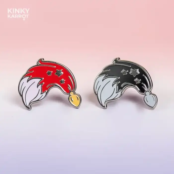 Side-by-side view of red and black fox tail butt plug enamel pins with star details