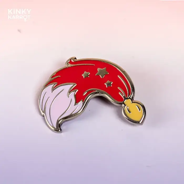 Red fox tail butt plug enamel pin with gold stars on a pink gradient background