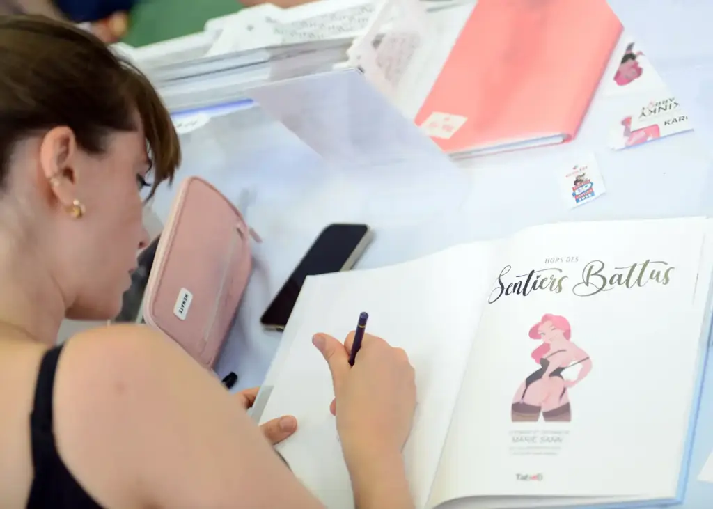 Kinky Karrot Artist Marie Sann signing her graphic novel hors des sentiers battus at a french comic festival