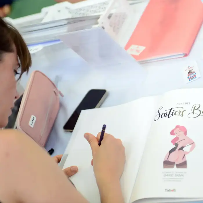 Kinky Karrot Artist Marie Sann signing her graphic novel hors des sentiers battus at a french comic festival
