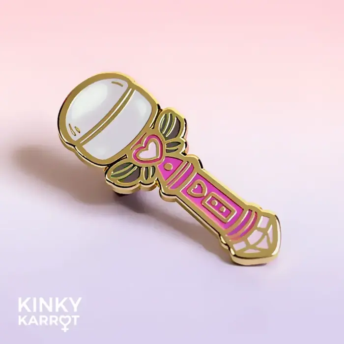 Magic wand enamel pin lying on gradient pink-purple background