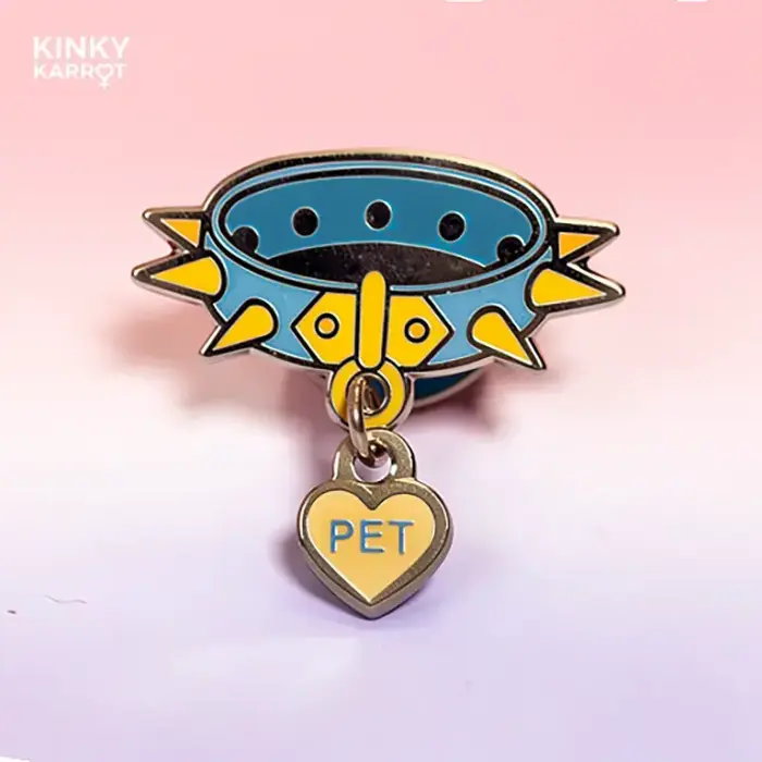 Close-up of the blue spiked collar enamel pin with “PET” charm