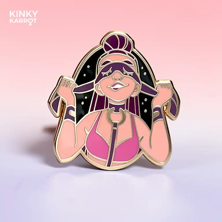 blindfold enamel pin with femme figure in pink harness smiling with mask