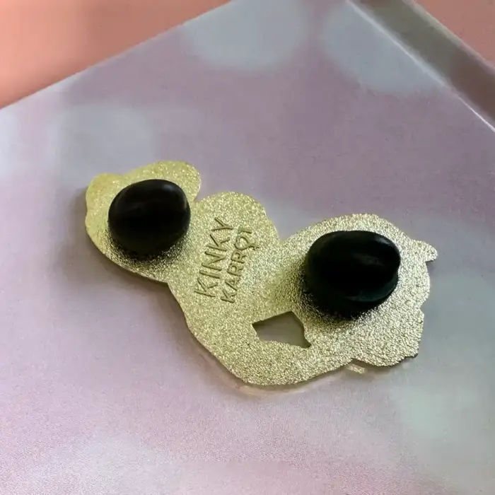 Back view of the Lizzy enamel pin showing gold metal base and double rubber clutches