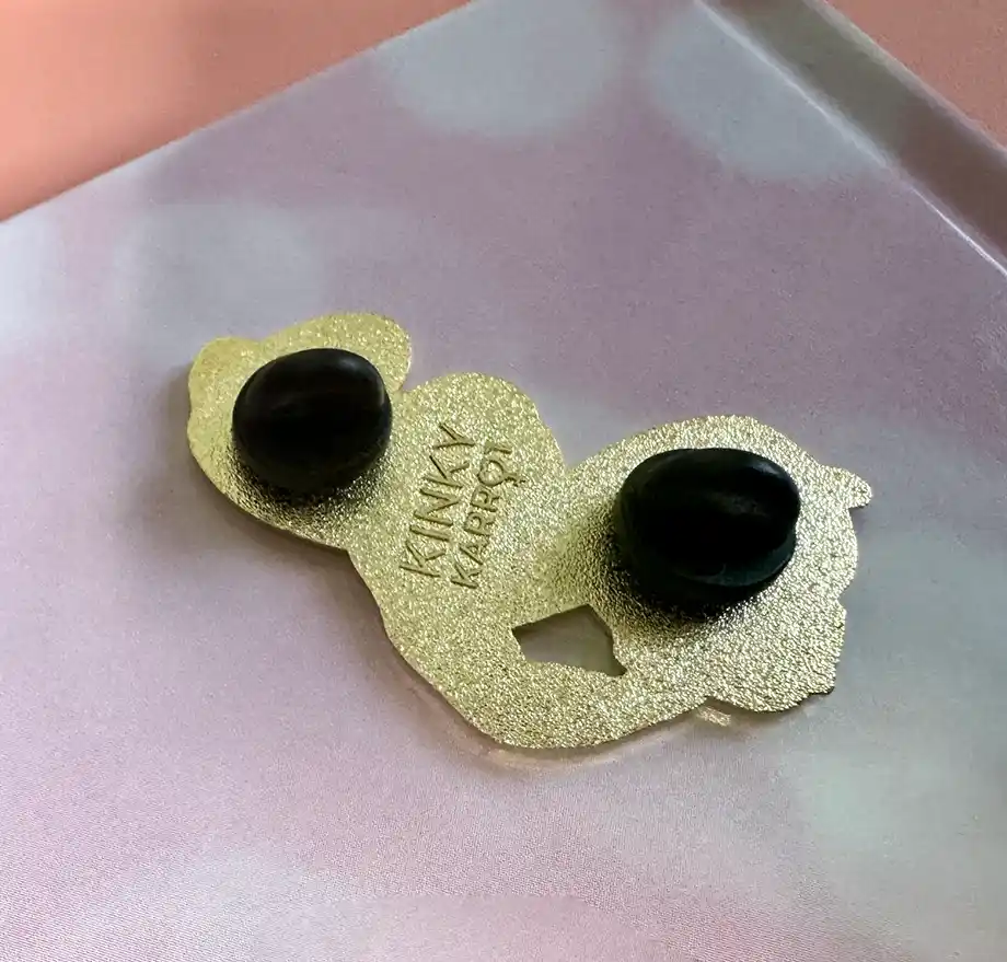 Back view of the Lizzy enamel pin showing gold metal base and double rubber clutches